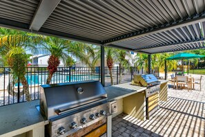 Enjoy al fresco dining and socializing in this outdoor patio area, featuring a barbecue grill and grill station, perfect for cooking up a meal.