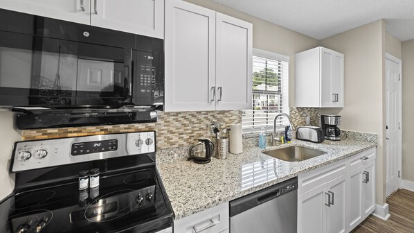 Enjoy cooking in this well-equipped kitchen with a microwave, stove, oven, and coffee maker.