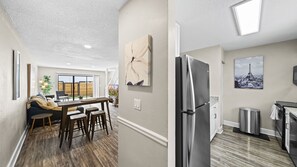 Enjoy a bright and airy living space with a large window, dining area, and modern kitchen.