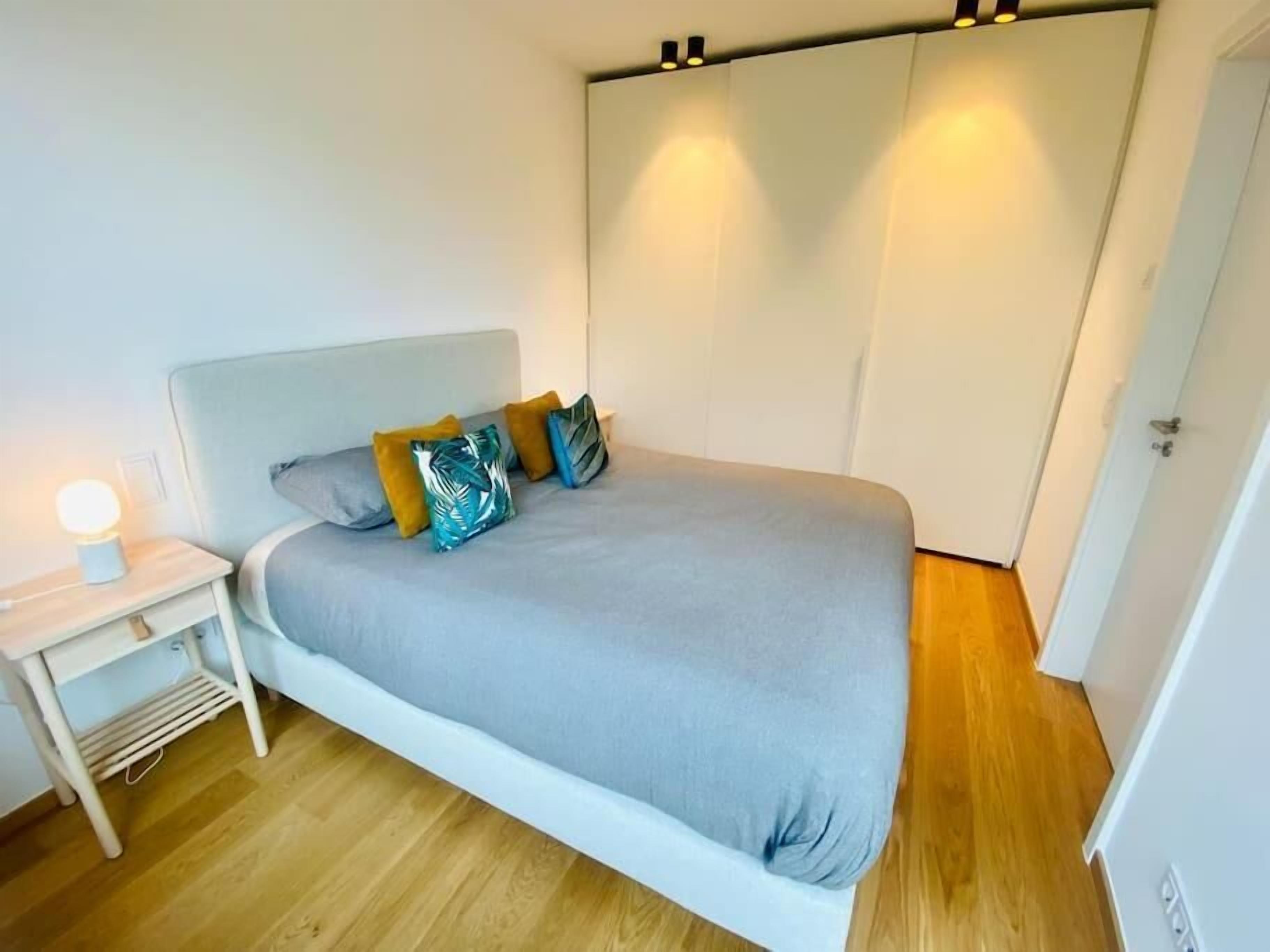 A bedroom with a bed, bedside table, and a wardrobe.