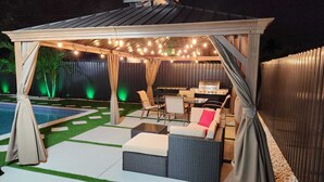 An outdoor patio area with a pool, seating, and a grill. - Luxury Miami Villa/Nr Beach/Heated POOL/BBQ/Firepit/Games/Minigolf/Basketball (Miami)