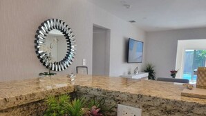A modern kitchen with granite countertops, a decorative mirror, and a welcome sign. - Luxury Miami Villa/Nr Beach/Heated POOL/BBQ/Firepit/Games/Minigolf/Basketball (Miami)