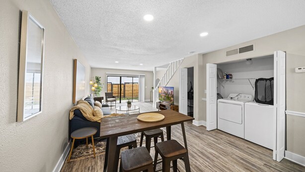 A modern kitchen with a dining area, a built-in washer and dryer, and a view to the backyard. - Cozy Townhome| Moffitt| Pool| Gym| Fast WiFi| 2B2B (Tampa)