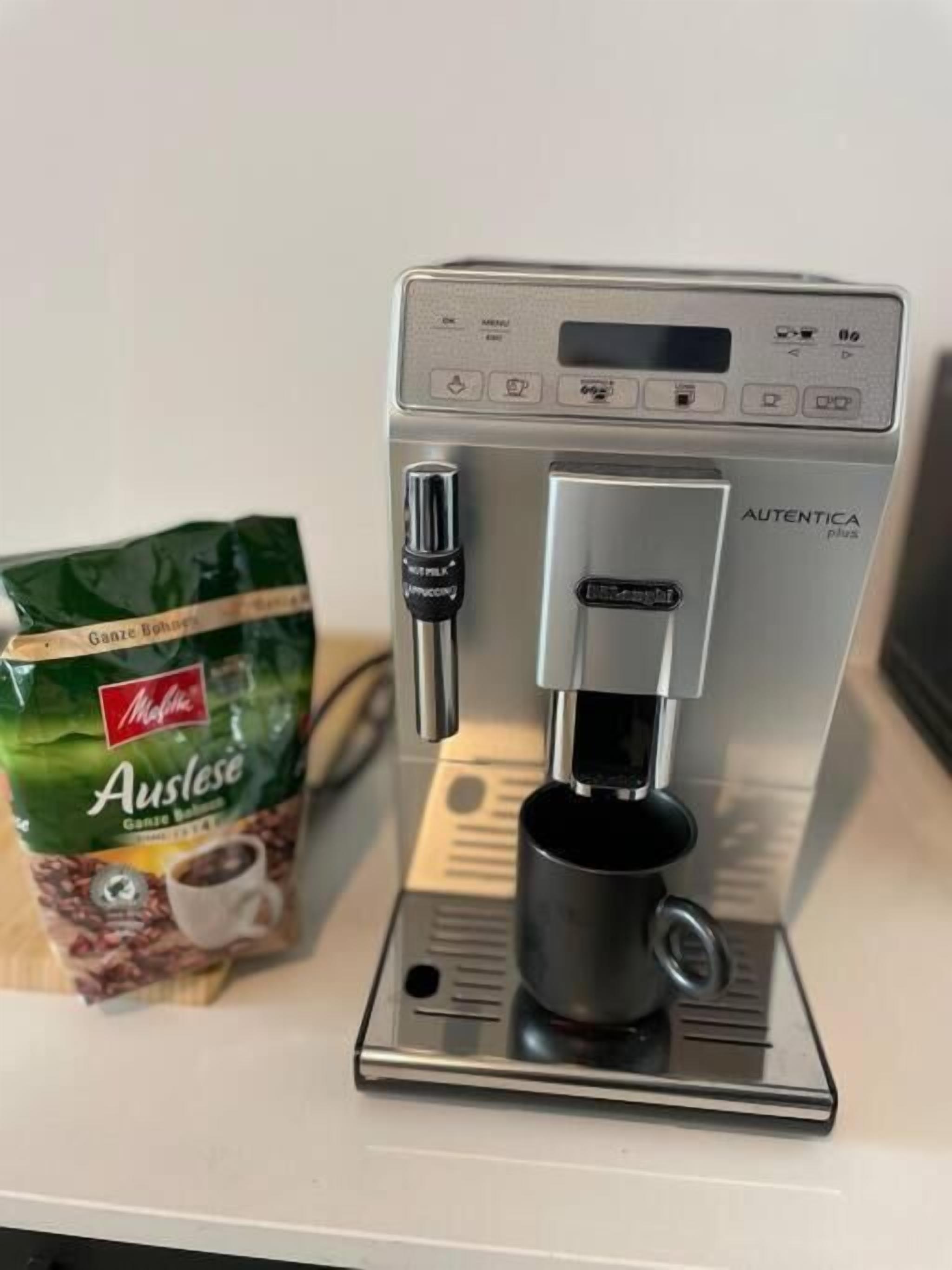 A coffee machine with a bag of coffee beans labeled "Auslese" next to it.