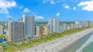 A coastal cityscape with high-rise buildings, a sandy beach, and a clear blue sky. - Modern*Oceanfront2BR*Pools*Downtown*HoneymoonSuite (Myrtle beach)