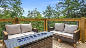 Eine Terrasse im Freien mit Korbmöbeln und einem Tisch mit Glasplatte.