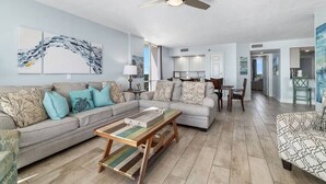 A spacious living room with a sofa, coffee table, and a ceiling fan. - Coastal Elegance Beachfront View (Pensacola)