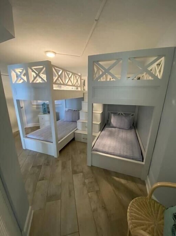 A room with two bunk beds, a small table, and a chair. - Coastal Elegance Beachfront View (Pensacola)