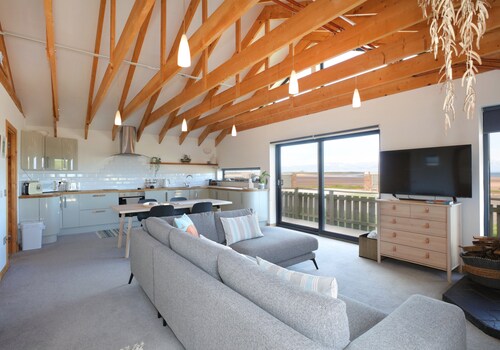 A modern, seafront chalet offering stunning beach views of Belhaven Bay.
