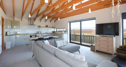 A modern, seafront chalet offering stunning beach views of Belhaven Bay.