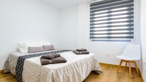 A bedroom with a bed, pillows, a chair, and a window with blinds. - A homely place with views in Jerica (Jérica)