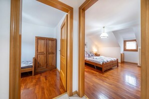 Camera da letto con un armadio in legno, un letto e un soffitto spiovente con una finestra.