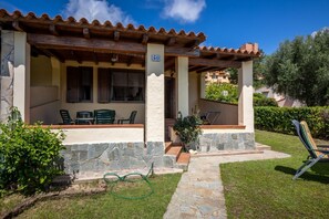 A building with a stone facade, a covered patio with chairs, and a number '50' sign. - GuestHost - Roomy villa of 66sqm located on two levels (stairs to access), can accommodate up to 5 people.The accommodation is located in Costa Rei, area served by all the main services: bars, restaurants, supermarkets and pharmacy. A few steps from the  (Costa Rei)