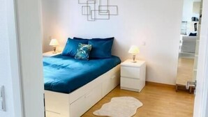 A bedroom with a bed, nightstands, a wall art piece, and a wooden floor. - Spac. Flat -Kirchberg w Parking&Terrace (Luxembourg City)