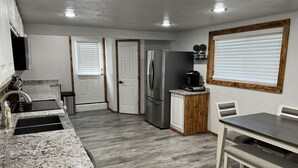 Una cocina moderna con encimeras de granito, un refrigerador de acero inoxidable y un horno empotrado.