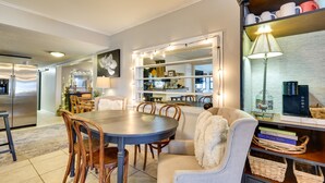 A modern kitchen with a dining area, featuring a large round table, wooden chairs, and a cozy seating area with a plush chair. - Waterfront Home w/ Dock in South Grand Lake! (Vinita)