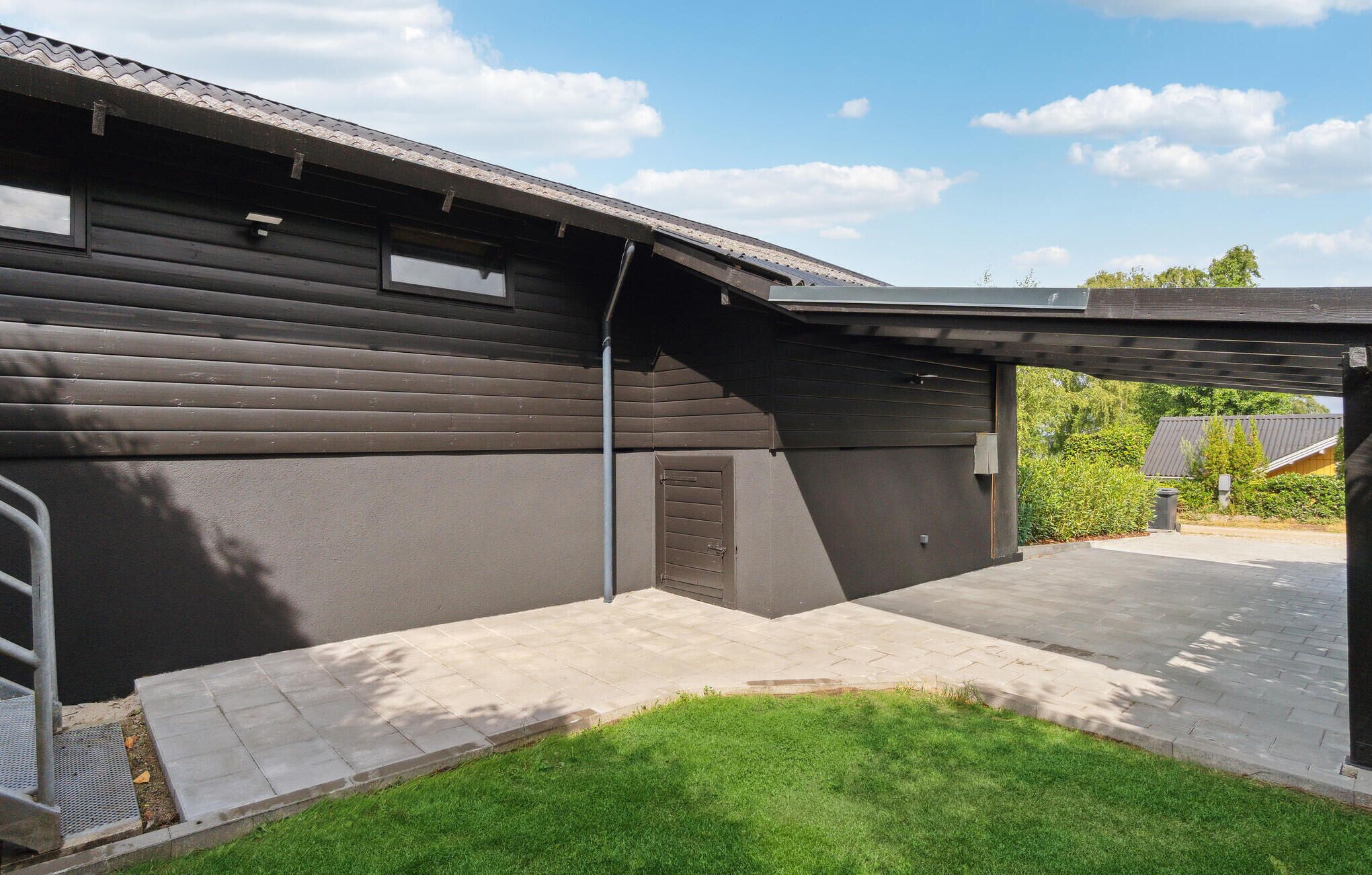 A modern building with a flat roof and a covered outdoor area.