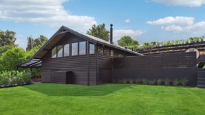 A modern log cabin with a sloped roof, large windows, and a chimney. - 1 bedroom lovely home in Holbæk (Holbæk)