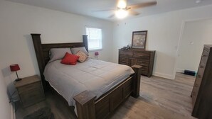 A bedroom with a wooden bed, a nightstand, a dresser, and a ceiling fan. - 3 Bedroom House Near Hickory  (Granite Falls)