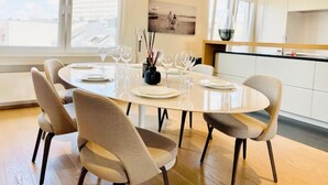 A modern dining area with a round table set for six, surrounded by six chairs.