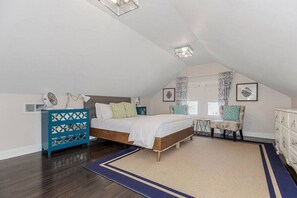 A bedroom with a bed, dresser, chair, and artwork on the walls. - Work & Relax in KC: Comfortable 2nd Floor Apt (2BR/2BA)| Near Plaza (Kansas City)