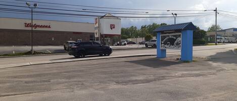 A Walgreens store with a parking lot and a blue roadside structure.