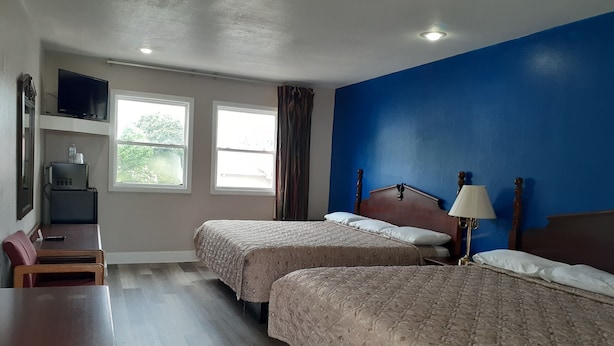 A hotel room with two beds, a desk, a TV, and a window with curtains. - Scenic River Inn Wartburg Hwy 27 (Wartburg)