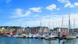 A marina with numerous sailboats docked along the waterfront, surrounded by buildings. - A Louer T2 Pour Trois Avec Piscine Dans la Résidence (ARZON)