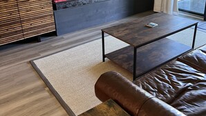 A modern living room with a fireplace, a sofa, a coffee table, and a television. - Spectacular Mountain Retreat (Winter Park)