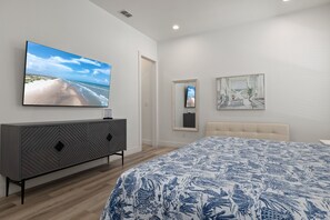 Ein Schlafzimmer mit einem großen Bett, einem Fernseher auf einem Schrank und Bildern an der Wand.