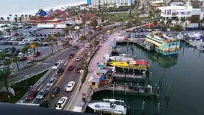 A coastal cityscape with a marina, a large hotel, and a busy road.