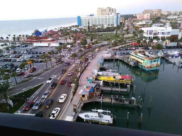 A coastal cityscape with a marina, a large hotel, and a busy road.