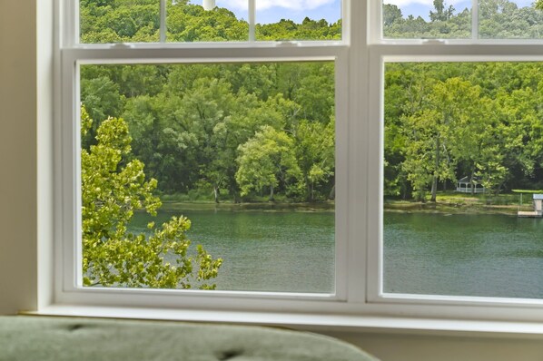 A window with a view of a lake surrounded by dense green trees. - Lakefront on Taneycomo with Fireplace, Just Minutes from Branson Landing (Branson)