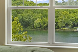 A window with a view of a lake surrounded by dense green trees. - Lakefront on Taneycomo with Fireplace, Just Minutes from Branson Landing (Branson)