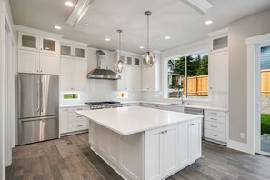 Una cocina moderna con armarios blancos, electrodomésticos de acero inoxidable y una isla grande.