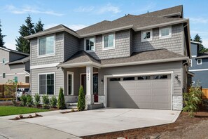 A two-story house with a garage, a covered porch, and a driveway.