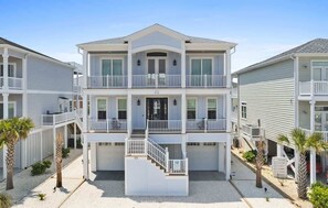 A multi-story residential building with balconies, a central entrance, and a covered walkway. - Blue Heaven by Brunswick Vacation Rentals: Home with Heated pool & Beach Club (Ocean Isle Beach)