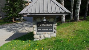 A stone sign with a metal roof labeled "The Marquise, 4809 Spearhead Drive."