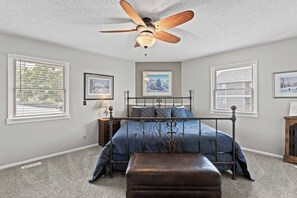 A bedroom with a bed, a ceiling fan, a window, and a picture on the wall. - Lazy Days M-01A - Three Bedroom House, Sleeps 10 (Osage Beach)