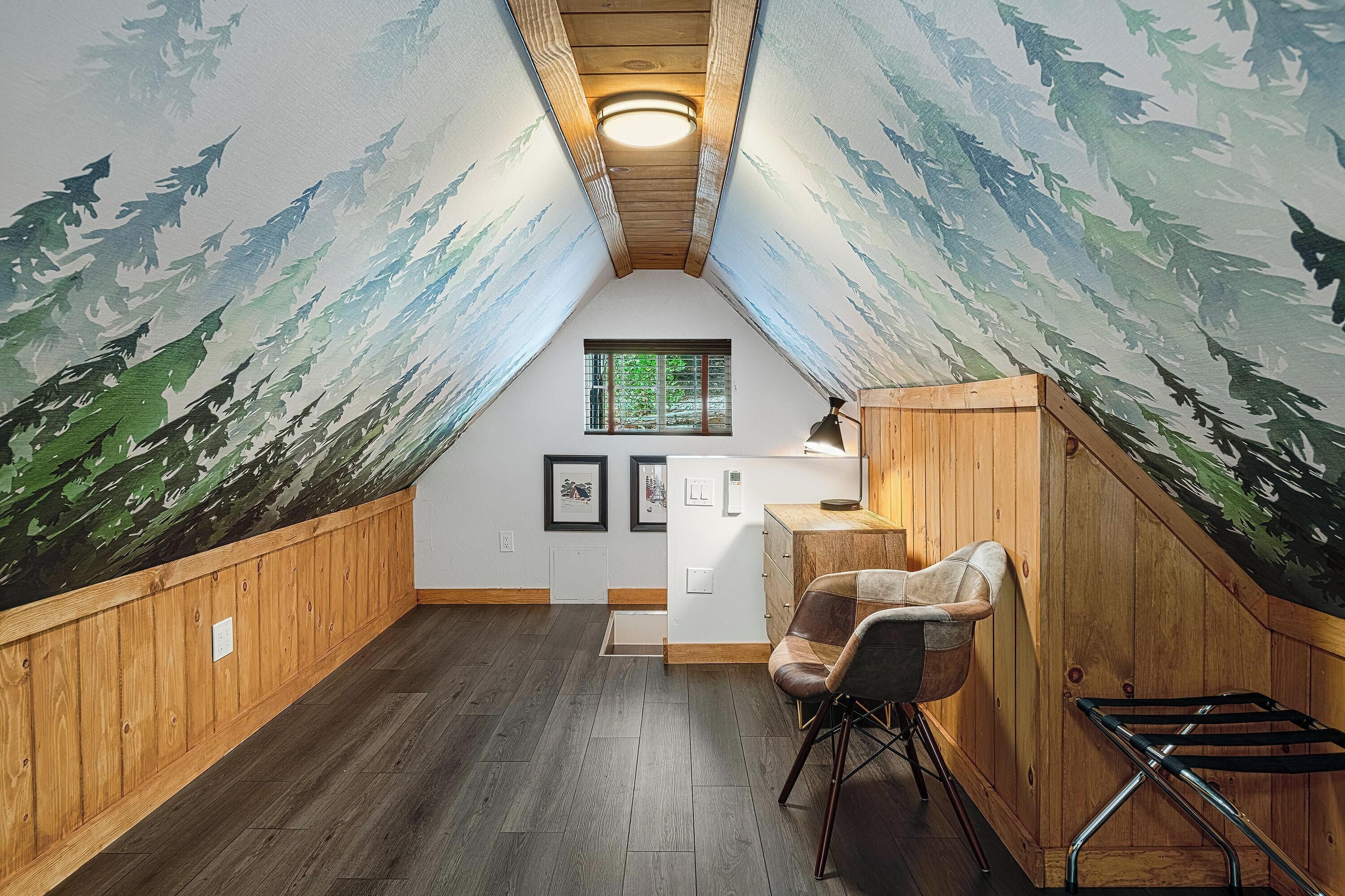 Une pièce mansardée chaleureuse avec des murs en bois, un plafond en pente et une fenêtre.