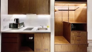 A modern kitchen with wooden cabinets, a microwave, and a coffee maker.