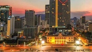 A cityscape at dusk with a prominent building featuring a heart-shaped design on its facade.