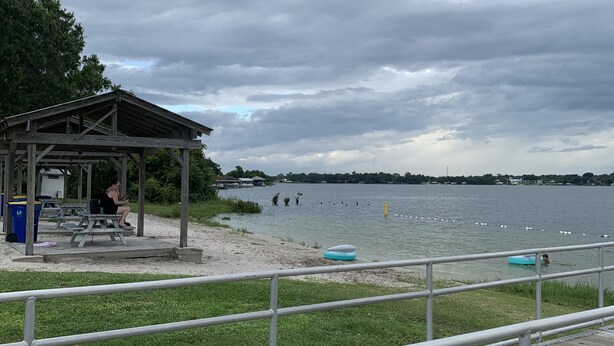 A lakeside park with picnic tables, a covered pavilion, and a wooden deck. - El Palacio de la Pesca (Lake Placid)