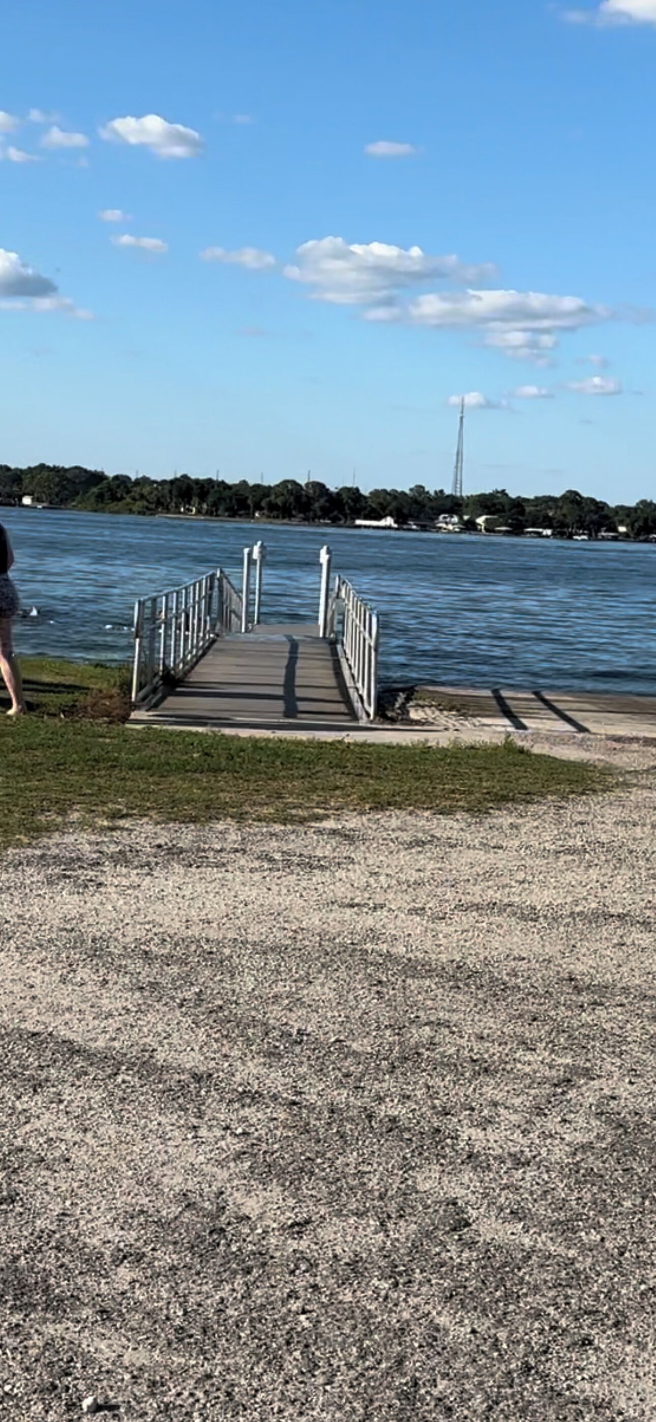 Un sendero de grava que conduce a un muelle de madera que se adentra en el agua.