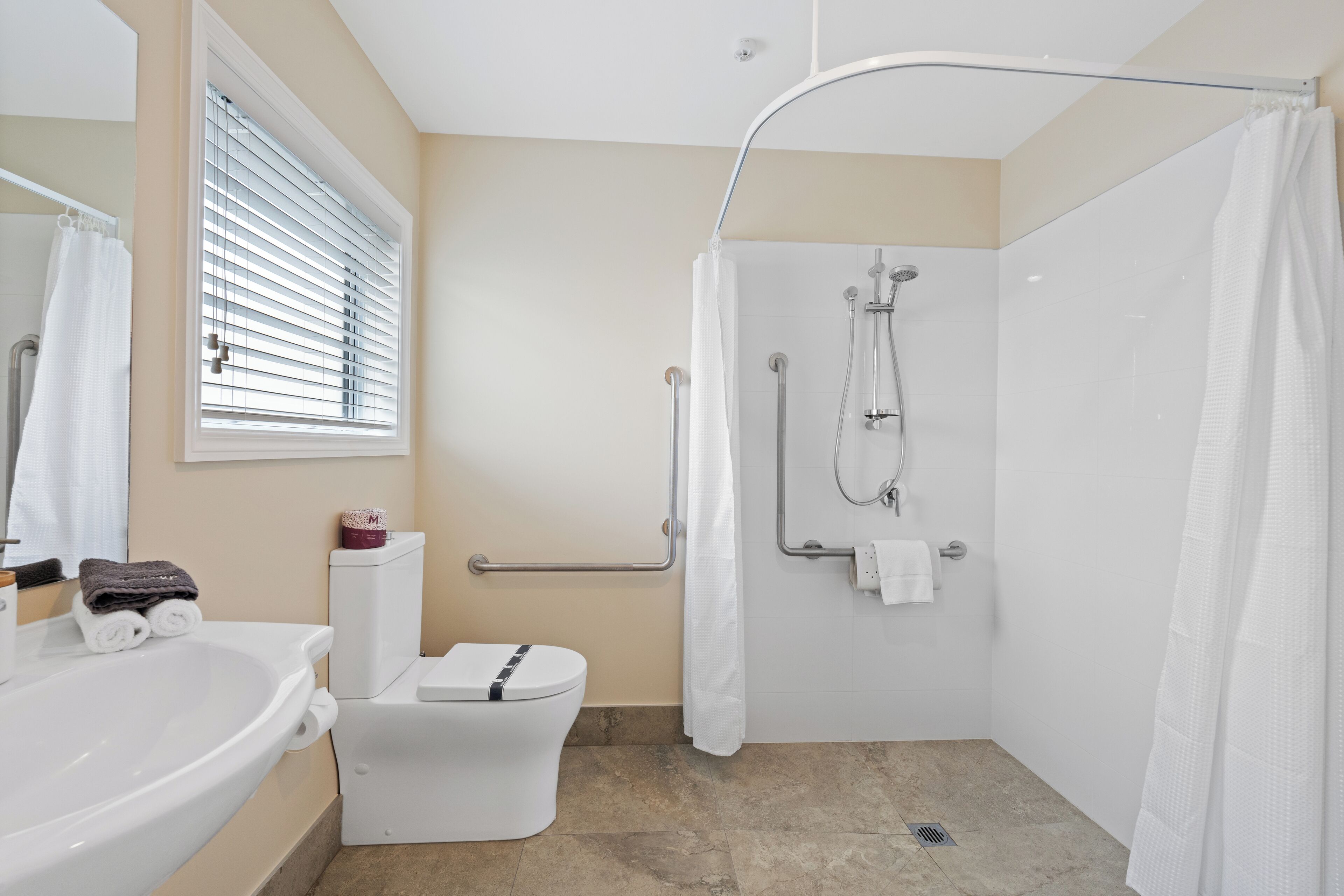 A modern bathroom with a shower, toilet, and sink.