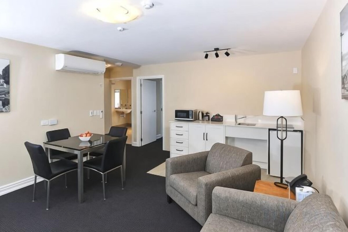 A compact living space with a dining area, kitchenette, and seating area.