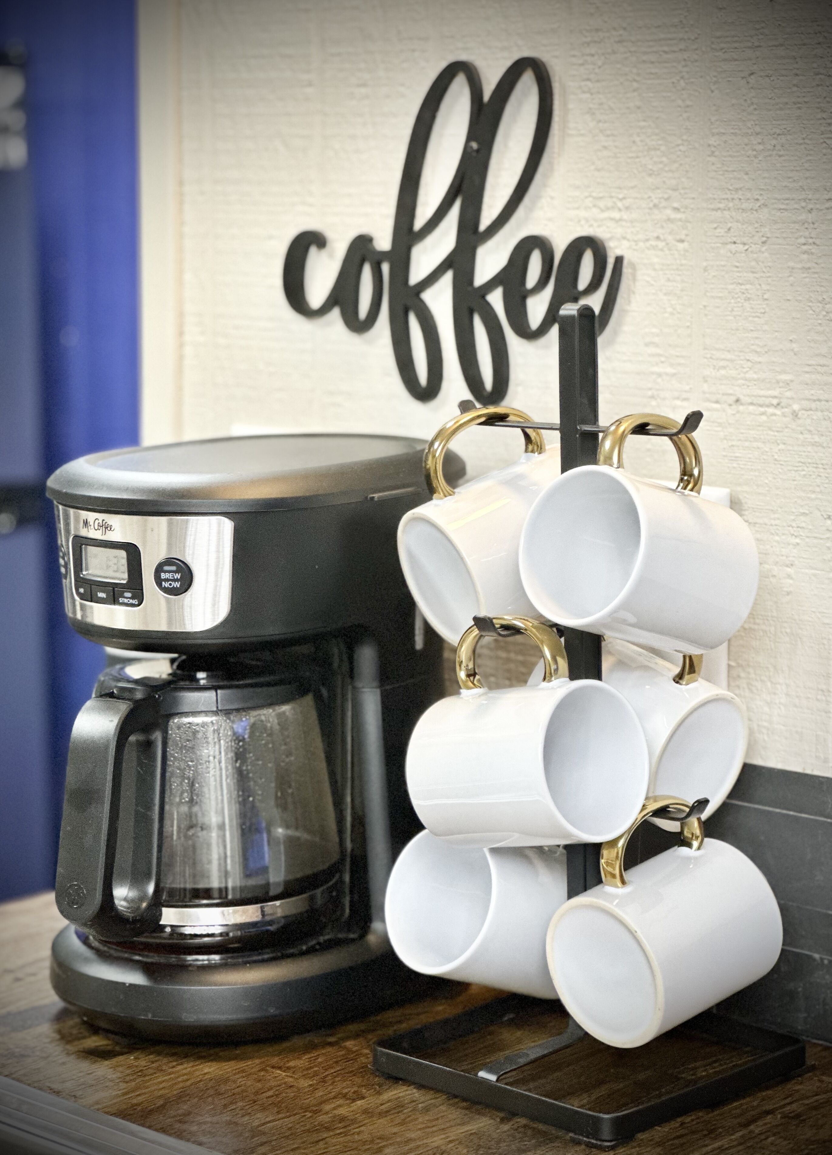 Une machine à café dotée d’un écran numérique et d’un porte-tasses permettant de ranger plusieurs tasses.