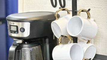 Une machine à café dotée d’un écran numérique et d’un porte-tasses permettant de ranger plusieurs tasses.