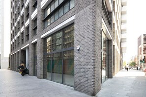 Un bâtiment moderne doté de grandes fenêtres et d’une façade en briques.