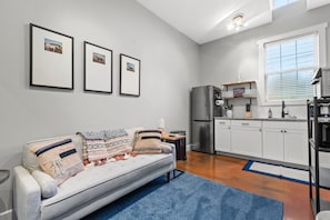 A modern living room with a sofa, a coffee table, and framed pictures on the wall. - Springside Bourbon Getaway (Georgetown)